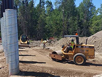 Preparing gravel borrow backfill for MSE wall at Lambert Bridge